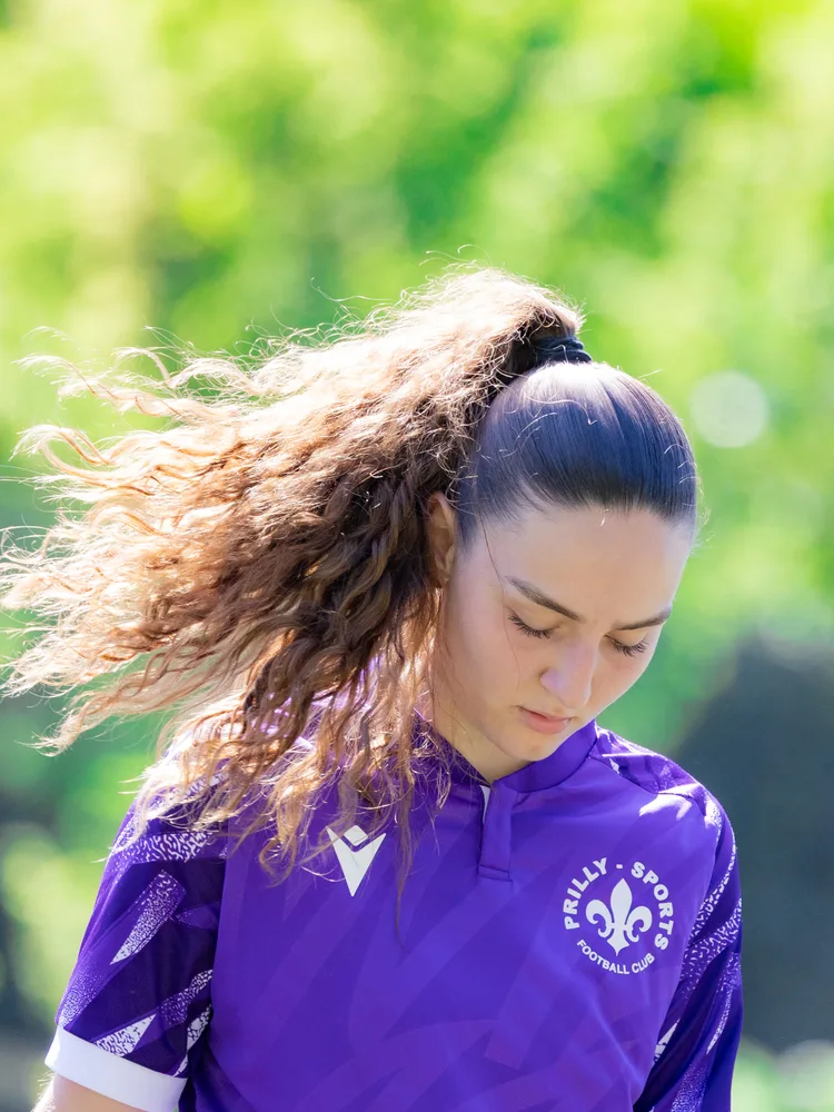 Une joueuse de l'équipe féminine, maillot violet, regard baissé